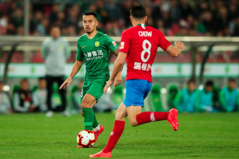 This photo taken on April 14, 2019 shows Nico Yennaris (L), also known as Li Ke, of Beijing Guoan controling the ball against Henan Jianye during their Chinese Super League match in Beijing. — AFP