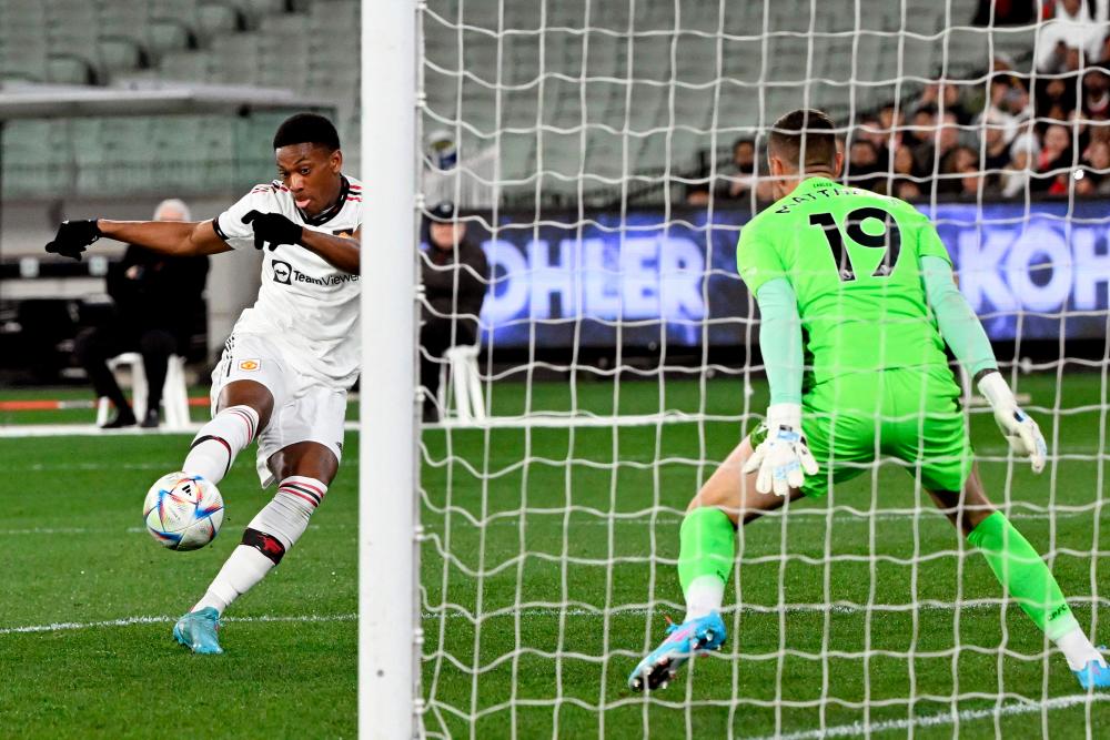 Manchester United player Anthony Martial (L) scores past Crystal Palace goalkeeper Remi Matthews (R) during the pre-season football match between English Premier League teams Manchester United and Crystal Palace at the Melbourne Cricket Ground (MCG) on July 19, 2022, in Melbourne. AFPPIX