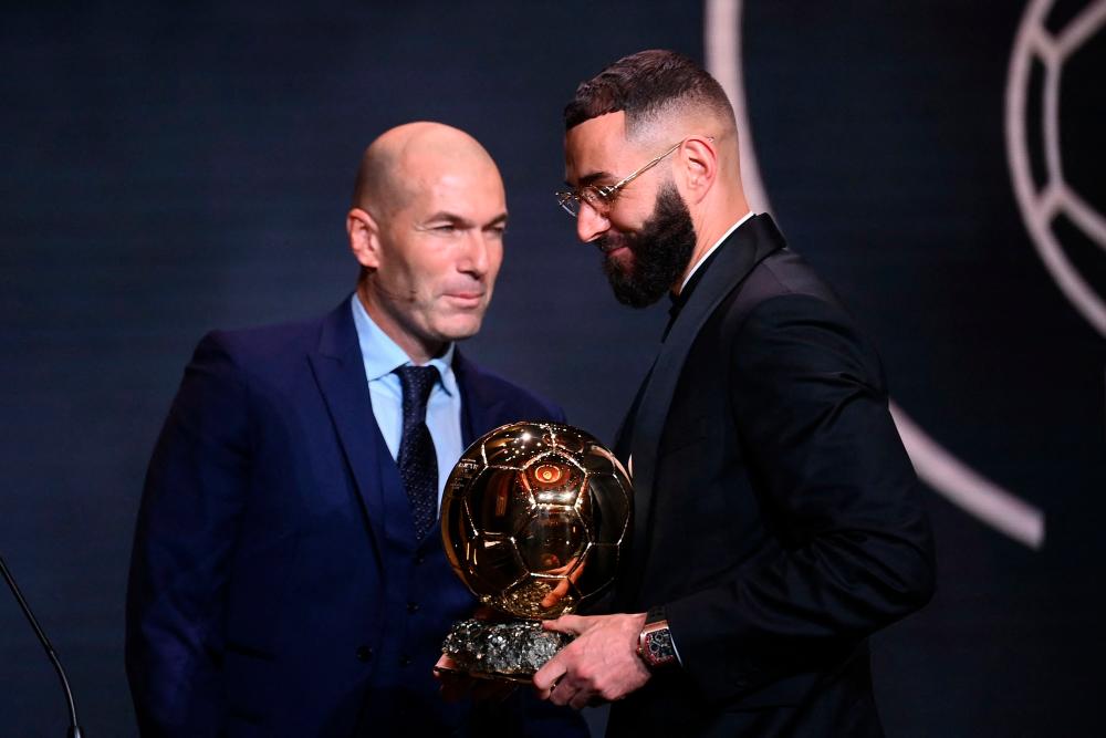 Real Madrid's French forward Karim Benzema receives the Ballon d'Or award from French former forward football player Zinedine Zidane during the 2022 Ballon d'Or France Football award ceremony at the Theatre du Chatelet in Paris on October 17, 2022. AFPPIX)