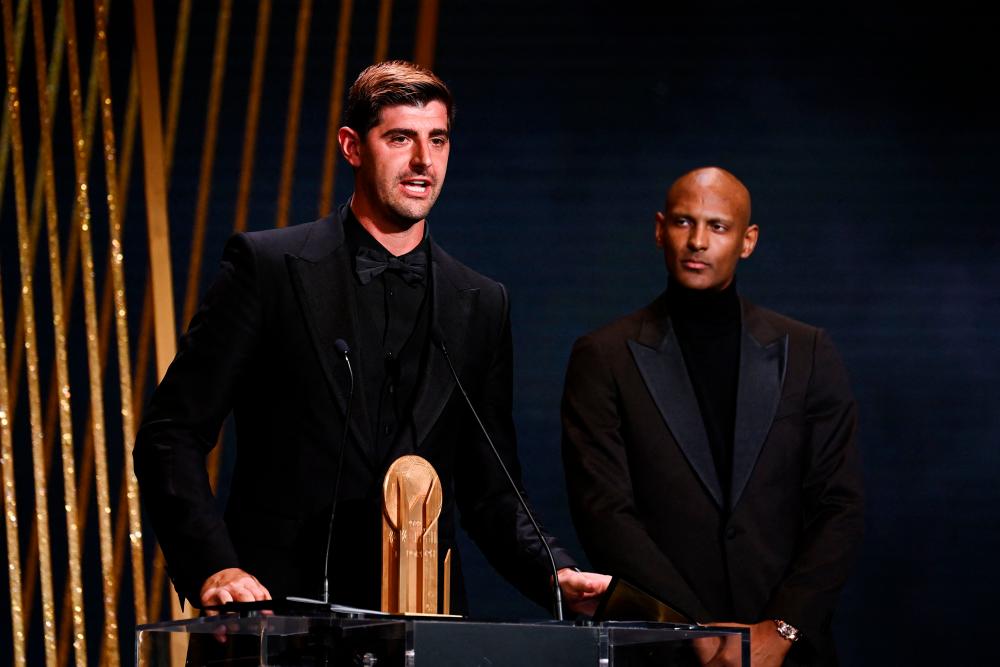 Real Madrid’s Belgian goalkeeper Thibaut Courtois (L) receives the Yashin Trophy for best goalkeeper from Dortmund’s Ivorian forward Sebastien Haller during the 2022 Ballon d’Or France Football award ceremony at the Theatre du Chatelet in Paris on October 17, 2022. AFPPIX