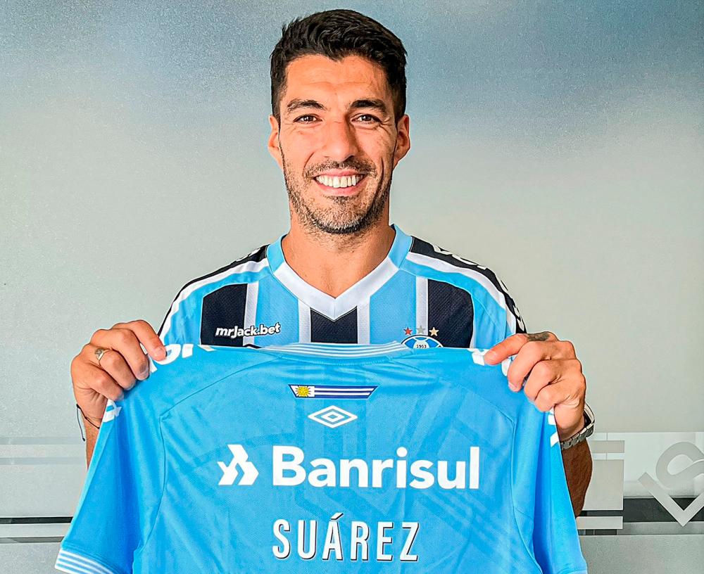 Handout picture released by Divulgacao Gremio FBPA on December 31, 2022, showing Uruguayan international striker Luis Suarez posing with his new jersey after signing a two-year contract with Brazilian football club Gremio, at his Complejo Suarez sports complex in Ciudad de la Costa, Canelones, Uruguay/AFPPix