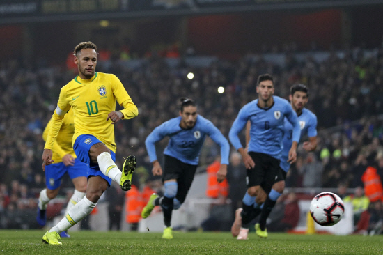 Brazil’s striker Neymar (L) scores the opening goal from the penalty spot during the international friendly football match against Uruguay at The Emirates Stadium in London on Nov 16, 2018. — AFP