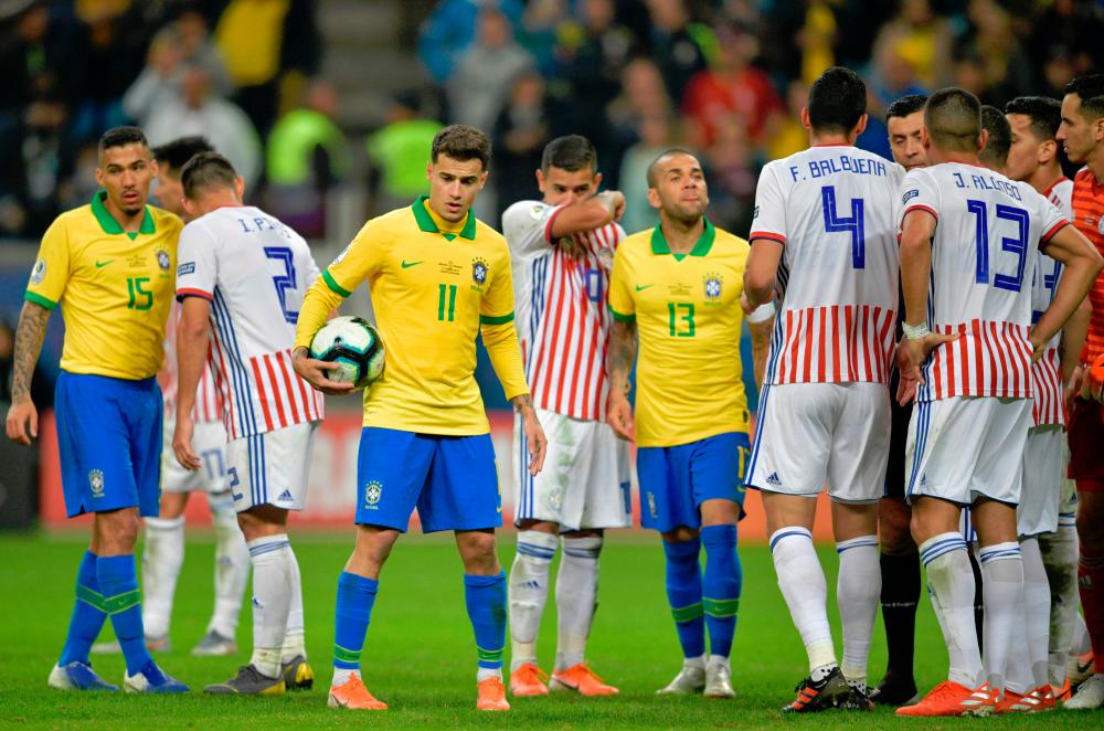 Brazil’s Philippe Coutinho (3-L) carries the ball before taking a free kick during the Copa America football tournament quarter-final match between Brazil and Paraguay at the Gremio Arena in Porto Alegre, Brazil, on June 27, 2019. — AFP