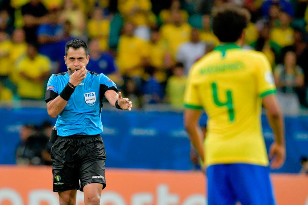 Chilean referee Julio Bascunan blows the final whistle of the Copa America football tournament group match between Brazil and Venezuela at the Fonte Nova Arena in Salvador, Brazil, on June 18, 2019. — AFP