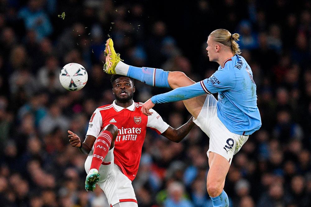 Manchester City's Norwegian striker Erling Haaland (R) challenges Arsenal's Ghanaian midfielder Thomas Partey during the English FA Cup fourth round football match between Manchester City and Arsenal at the Etihad Stadium in Manchester, northwest England, on January 27, 2023. AFPPIX