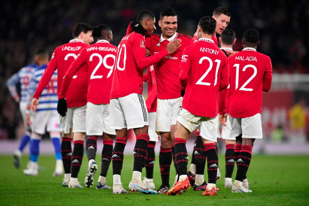 Manchester United's Brazilian midfielder Casemiro (C) celebrates with teammates after scoring their second goal during the English FA Cup fourth round football match between Manchester United and Reading at Old Trafford in Manchester, north west England, on January 28, 2023. - AFPPIX