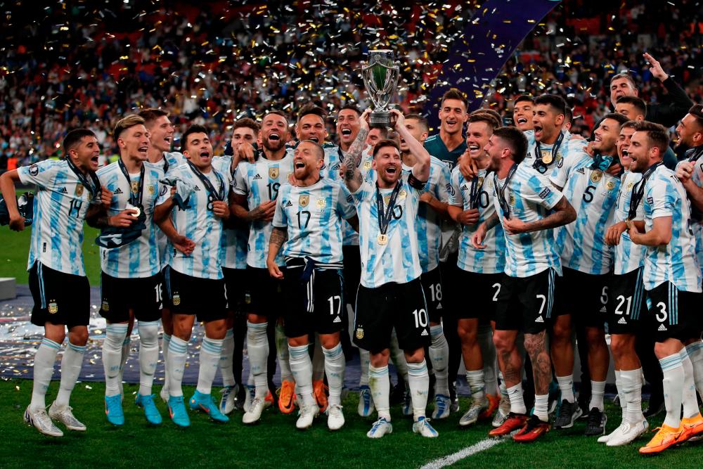 Argentina's striker Lionel Messi lifts the trophy as Argentina's players celebrate on the pitch after their victory in the 'Finalissima' International friendly football match between Italy and Argentina at Wembley Stadium in London on June 1, 2022. AFPPIX
