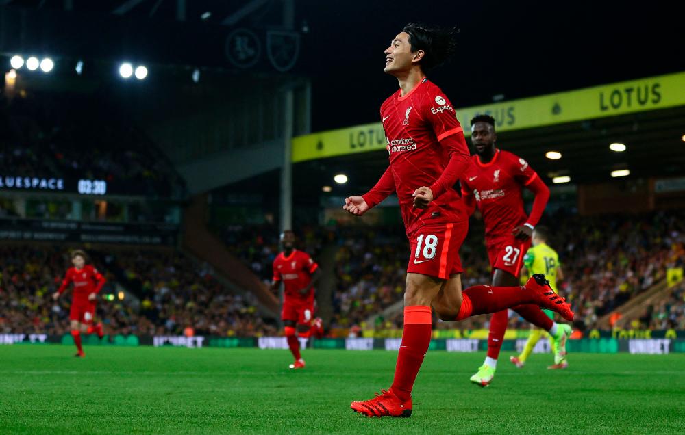 Liverpool’s Japanese midfielder Takumi Minamino celebrates scoring the opening goal during the English League Cup third round football match between Norwich City and Liverpool – AFPPIX