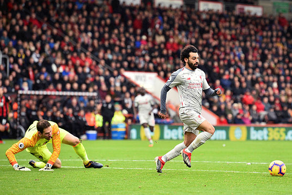 Liverpool’s Egyptian midfielder Mohamed Salah (R) takes the ball around Bournemouth’s Bosnian-Herzegovinian goalkeeper Asmir Begovic (L) in the build-up to scoring his third goal, Liverpool’s fourth during the English Premier League football match between Bournemouth and Liverpool at the Vitality Stadium in Bournemouth, England on Dec 8, 2018. — AFP