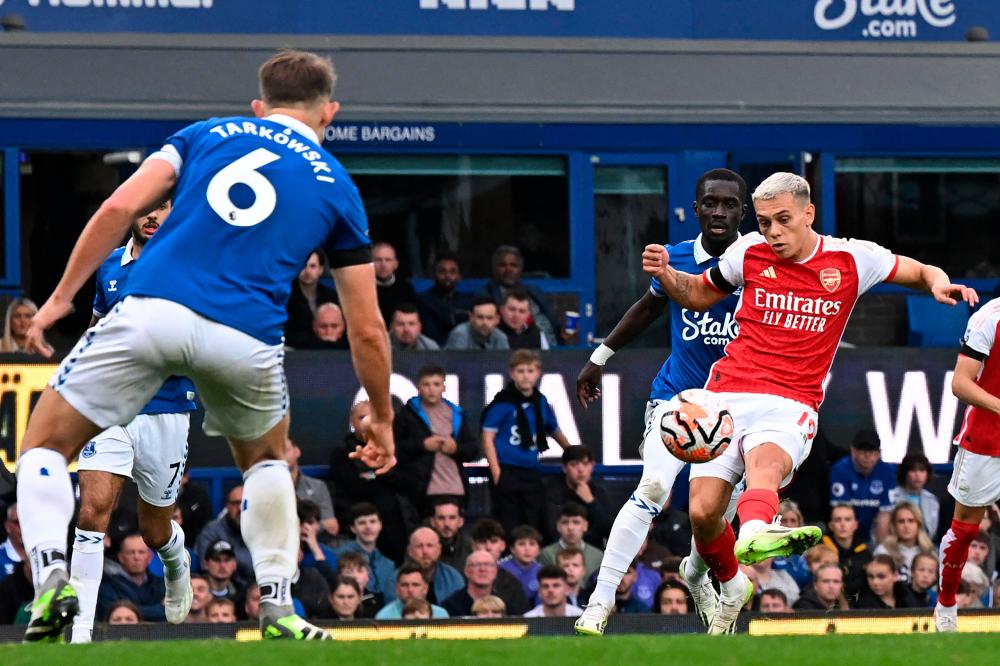 Leandro Trossard (R) shoots to score the opening goal of the English Premier League football match between Everton and Arsenal at Goodison Park in Liverpool, north west England on September 17, 2023. AFPPIX