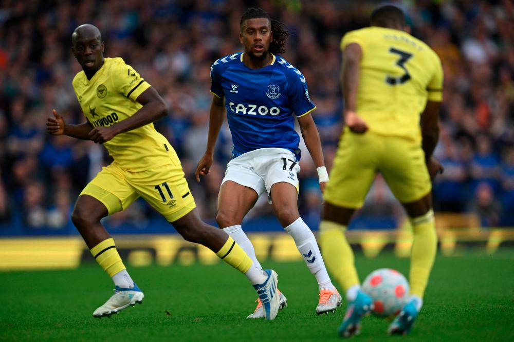 Everton's Nigerian midfielder Alex Iwobi (C) eyes the ball controled by Brentford's English defender Rico Henry (R) during the English Premier League football match between Everton and Brentford at Goodison Park. AFPPIX