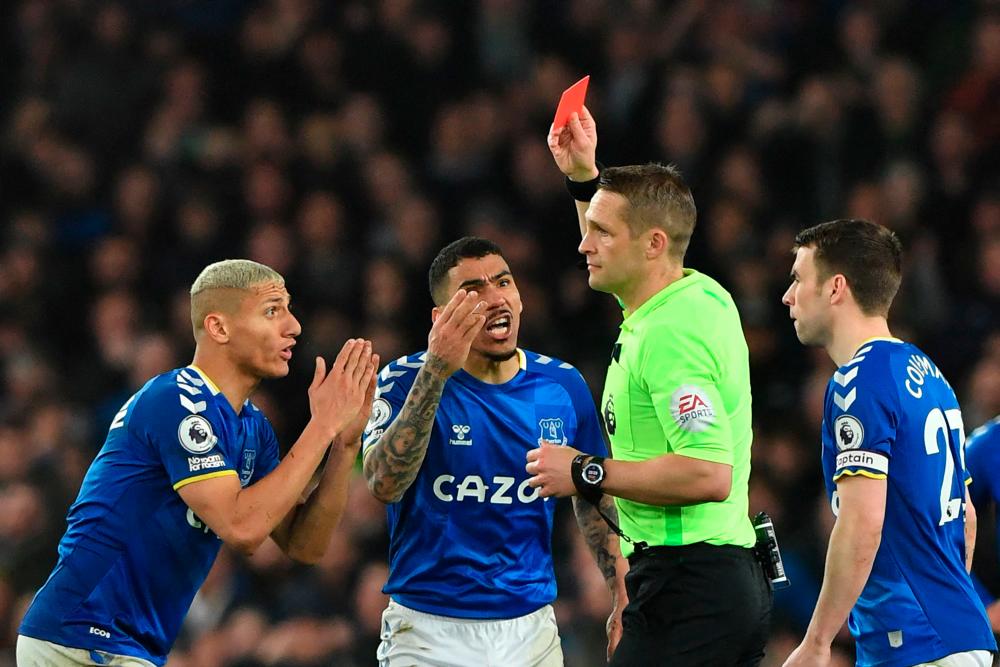 English referee Craig Pawson shows a red card to Everton's Brazilian midfielder Allan (C) during the English Premier League football match between Everton and Newcastle United at Goodison Park in Liverpool, north west England on March 17, 2022. - AFPpix