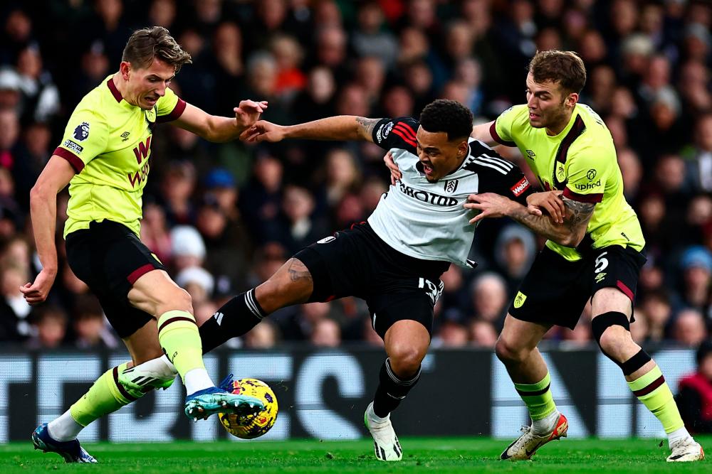 Fulham's Brazilian striker #19 Rodrigo Muniz (C) vies with Burnley's Norwegian midfielder #16 Sander Berge and Burnley's German defender #05 Jordan Beyer (R)ju during the English Premier League football match between Fulham and Burnley at Craven Cottage in London on December 23, 2023. - AFPPIX