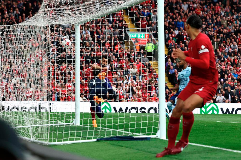 Mohamed Salah (L) kicks to score his team's first goal during the English Premier League football match between Liverpool and Brentford at Anfield in Liverpool, north west England on May 6, 2023. AFPPIX