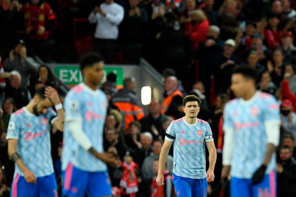 Manchester United’s English defender Harry Maguire (2nd R) reacts after Liverpool’s Egyptian midfielder Mohamed Salah scored his team second goal during the English Premier League football match between Liverpool and Manchester United at Anfield in Liverpool, north west England on April 19, 2022. AFPPIX