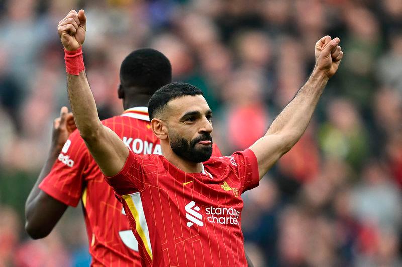 Liverpool’s Egyptian striker #11 Mohamed Salah celebrates scoring the team’s third goal from the penalty spot during the English Premier League football match between Liverpool and Southampton at Anfield in Liverpool - AFPPIX