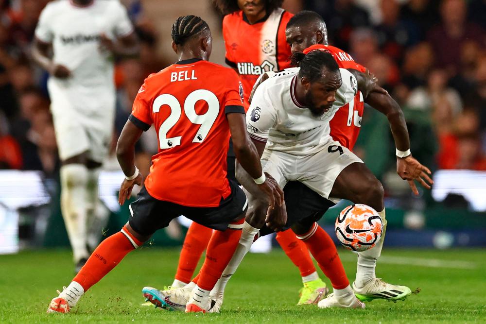 Michail Antonio (C) vies with Amari'i Bell (L) and Luton Town's Marvelous Nakamba (R) during the English Premier League football match between Luton Town and West Ham United at Kenilworth Road in Luton, north of London on September 1, 2023. AFPPIX