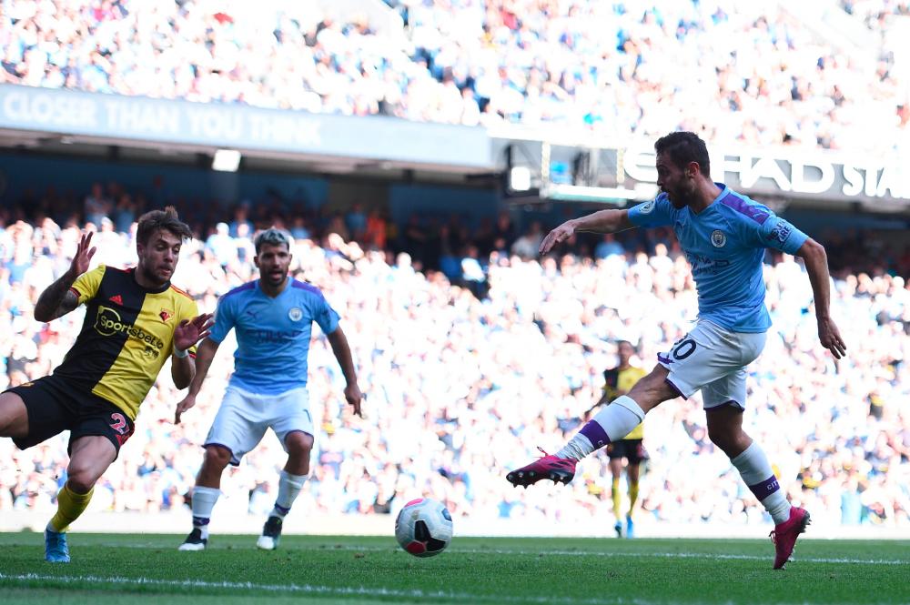 Manchester City's Portuguese midfielder Bernardo Silva (R) scores the team's seventh goal during the English Premier League football match between Manchester City and Watford at the Etihad Stadium in Manchester, England, on Sept 21, 2019. - AFP