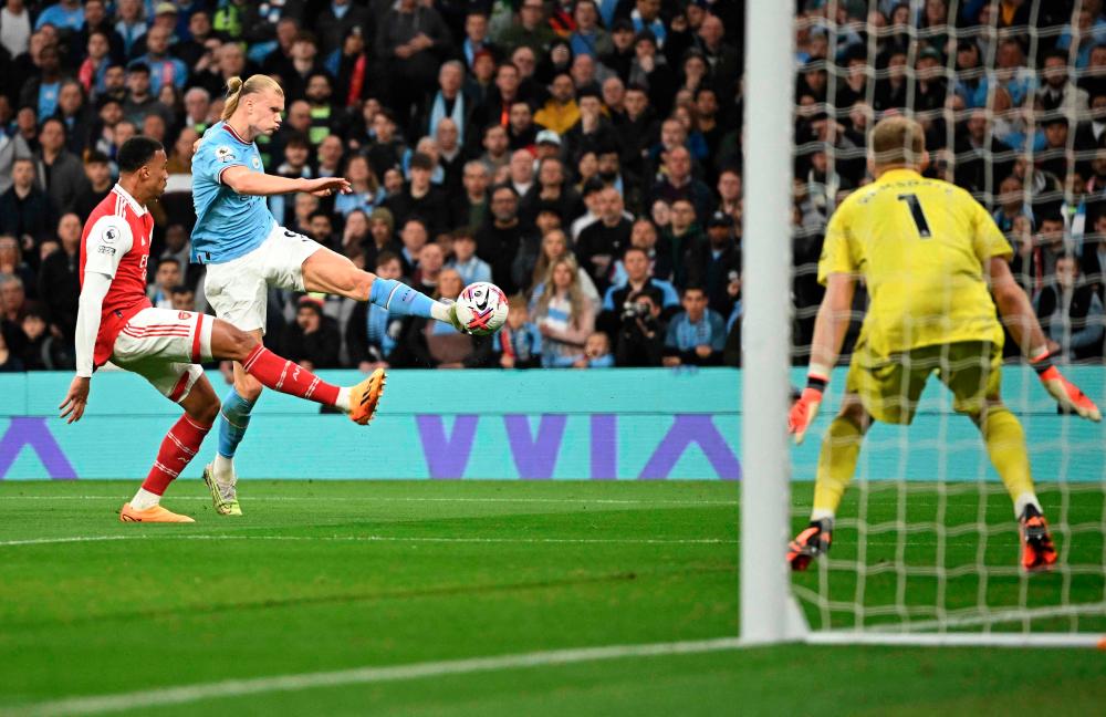 Aaron Ramsdale (R) saves a shot by Erling Haaland during the English Premier League football match between Manchester City and Arsenal at the Etihad Stadium in Manchester, north west England, on April 26, 2023. AFPPIX
