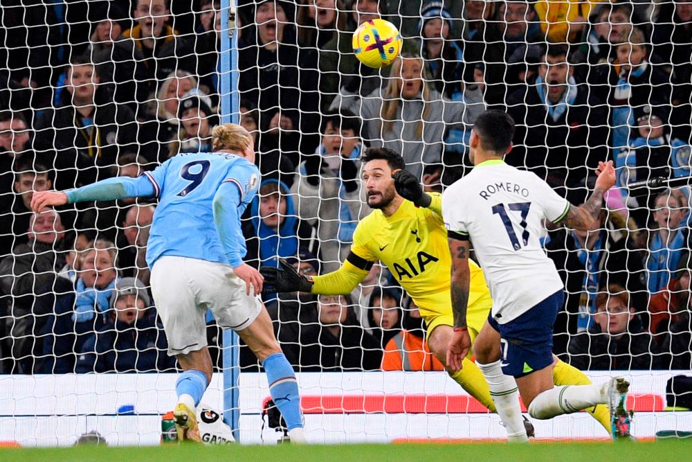 Manchester City’s Norwegian striker Erling Haaland (L) scores the team’s second goal past Tottenham Hotspur’s French goalkeeper Hugo Lloris during the English Premier League football match between Manchester City and Tottenham Hotspur at the Etihad Stadium in Manchester, north west England, on January 19, 2023. AFPPIX