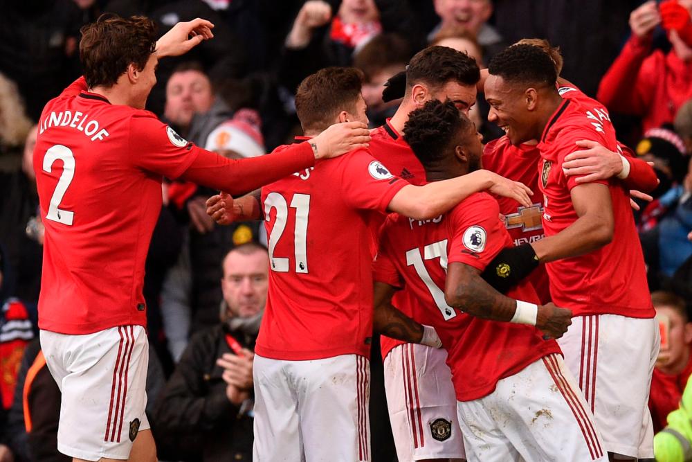 Manchester United's French striker Anthony Martial (1st-R) celebrates scoring his team's first goal during the English Premier League football match between Manchester United and Manchester City at Old Trafford in Manchester, north west England, on March 8, 2020. — AFP