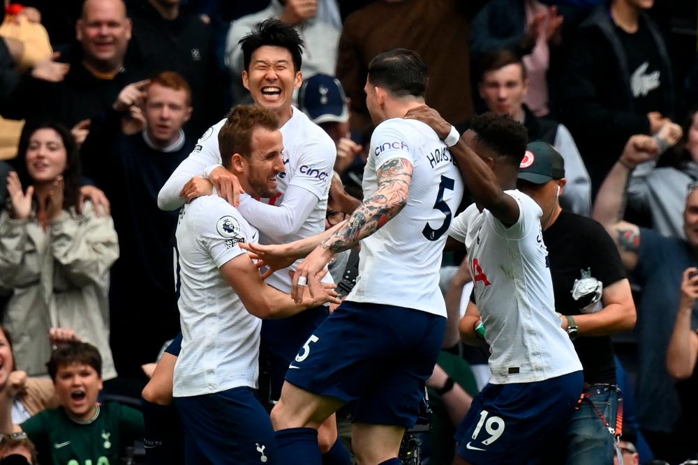 Tottenham Hotspur’s English striker Harry Kane (L) celebrates with teammates after scoring the opening goal from the penalty spot during the English Premier League football match between Tottenham Hotspur and Burnley at Tottenham Hotspur Stadium in London, on May 15, 2022. AFPPIX
