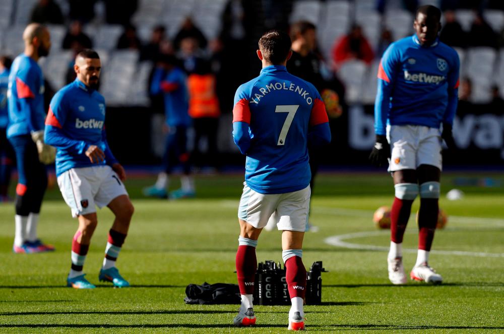 West Ham players wearing shirts bearing the name of their teammate Ukrainian striker Andriy Yarmolenko, warm up during the English Premier League football match between West Ham United and Wolverhampton Wanderers at the London Stadium, in London on February 27, 2022. AFPPIX
