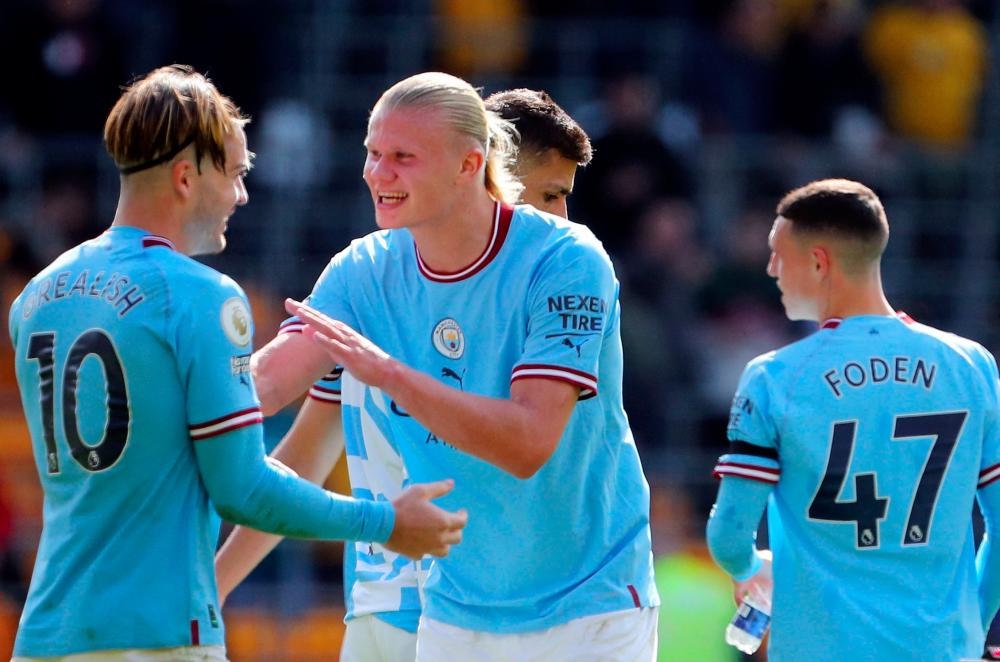 Goalscorers Manchester City's English midfielder Jack Grealish (L), Manchester City's Norwegian striker Erling Haaland (C) and Manchester City's English midfielder Phil Foden celebrate after the English Premier League football match between Wolverhampton Wanderers and Manchester City at the Molineux stadium in Wolverhampton, central England on September 17, 2022. - REUTERSPIX