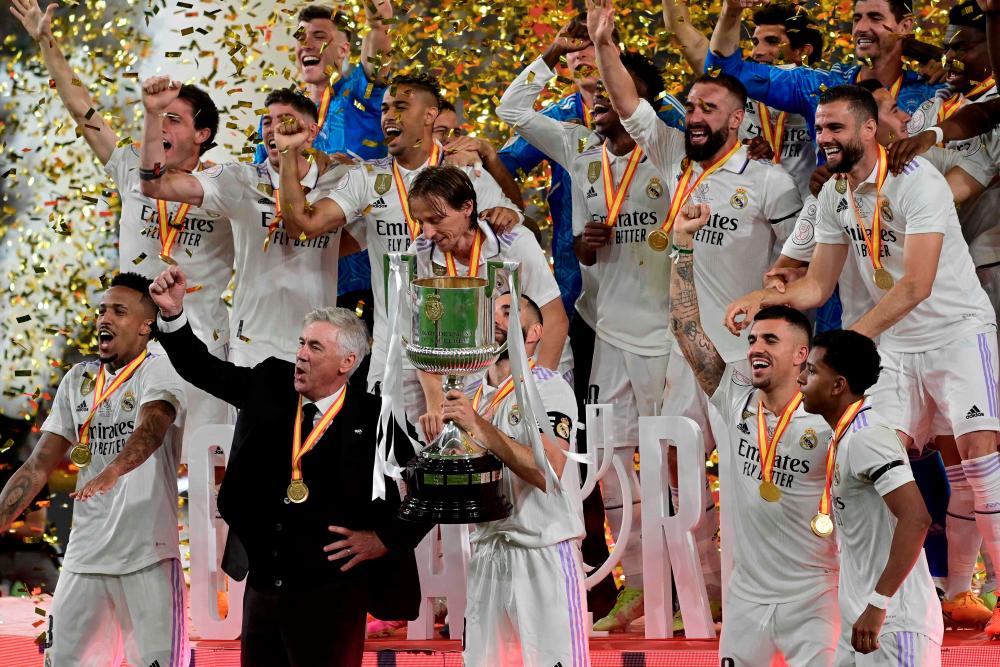 Karim Benzema (C), Carlo Ancelotti (2nd-L) and teammates celebrate with the trophy after winning the Spanish Copa del Rey (King's Cup) final football match between Real Madrid CF and CA Osasuna at La Cartuja stadium in Seville on May 6, 2023. AFPPIX
