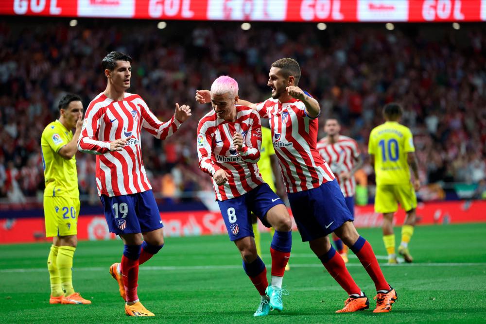 Atletico Madrid’s French forward Antoine Griezmann (C) celebrates scoring the opening goal with Atletico Madrid’s Spanish midfielder Koke (R) and Atletico Madrid’s Spanish forward Alvaro Morata during the Spanish league football match between Club Atletico de Madrid and Cadiz CF at the Wanda Metropolitano stadium in Madrid on May 3, 2023/AFPPix