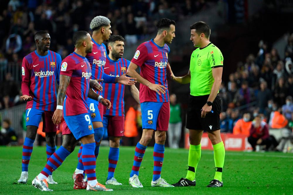 Barcelona's Spanish midfielder Sergio Busquets (2ndR) and players talk to the referee during the Spanish league football match between FC Barcelona and Rayo Vallecano de Madrid at the Camp Nou stadium in Barcelona/AFPPix