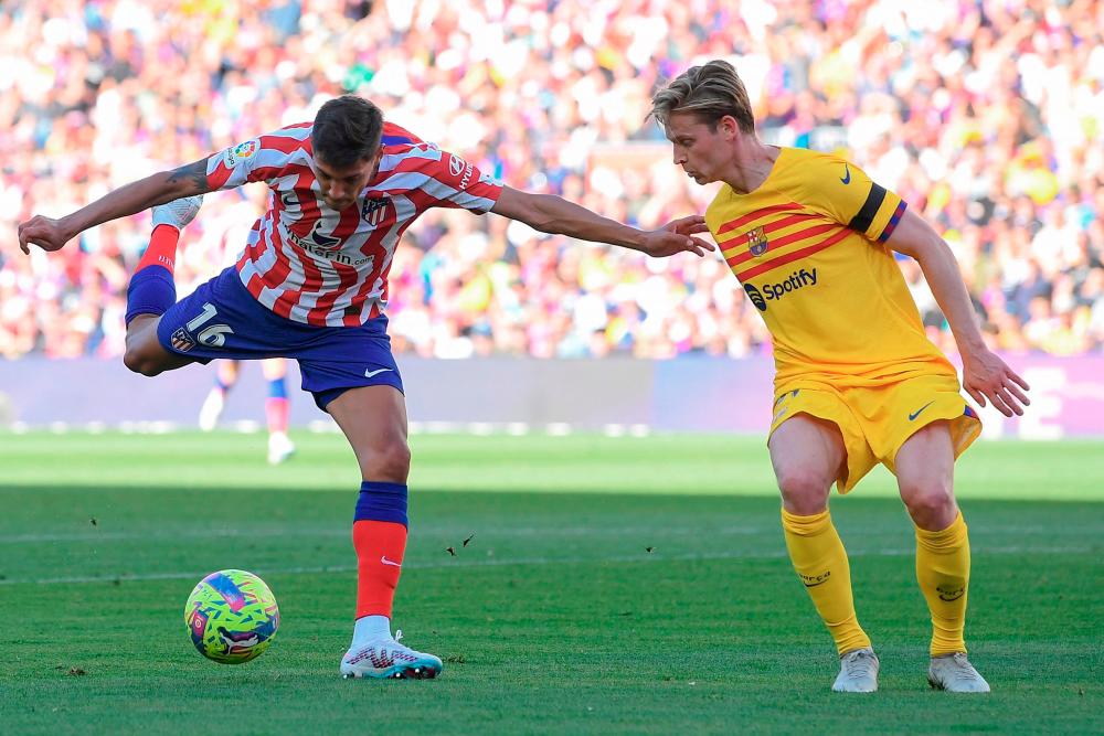 Nahuel Molina (L) vies with Frenkie de Jong during the Spanish league football match between FC Barcelona and Club Atletico de Madrid at the Camp Nou stadium in Barcelona on April 23, 2023. AFPPIX