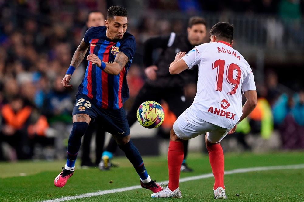 Barcelona’s Brazilian forward Raphinha (L) fights for the ball with Sevilla’s Argentinian defender Marcos Acuna during the Spanish league football match between FC Barcelona and Sevilla FC at the Camp Nou stadium in Barcelona, on February 5, 2023/AFPPix