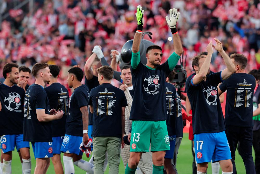 Girona players celebrate their qualification for the UEFA Champions League at the end of the Spanish league football match between Girona FC and FC Barcelona at the Montilivi stadium in Girona on May 4, 2024. - AFPPIX