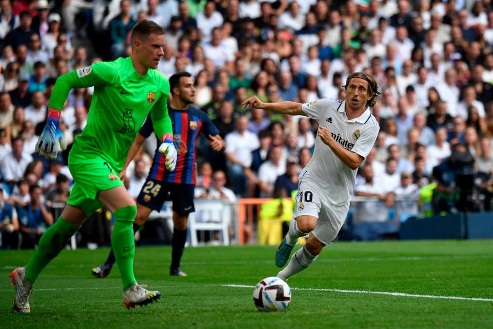 Real Madrid’s Croatian midfielder Luka Modric (R) vies with Barcelona’s German goalkeeper Marc-Andre ter Stegen during the Spanish League football match between Real Madrid CF and FC Barcelona at the Santiago Bernabeu stadium on October 16, 2022/AFPPix