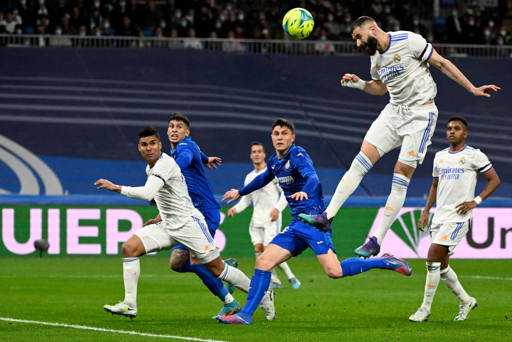 Real Madrid's Luka Modric, right, heads the ball past Manchester