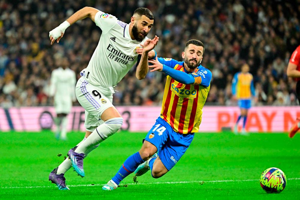 Real Madrid’s French forward Karim Benzema (L) vies with Valencia’s Spanish defender Jose Gaya during the Spanish league football match between Real Madrid CF and Valencia CF at the Santiago Bernabeu stadium in Madrid on February 2, 2023/AFPPix