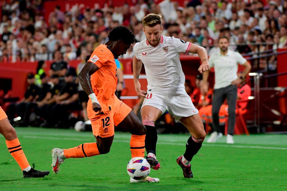 Sevilla’s Croatian midfielder #10 Ivan Rakitic (R) vies with Valencia’s Portuguese defender #12 Thierry Correia during the Spanish Liga football match between Sevilla FC and Valencia CF at the Ramon Sanchez Pizjuan stadium in Seville on August 11, 2023/AFPPix