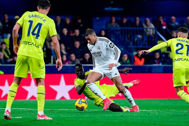 Real Madrid's French forward #09 Kylian Mbappe (C) runs past Villarreal's Senegalese midfielder #18 Pape Gueye during the Spanish League football match between Villarreal CF and Real Madrid CF at La Ceramica Stadium in Vila-real on March 15, 2025. - AFPPIX