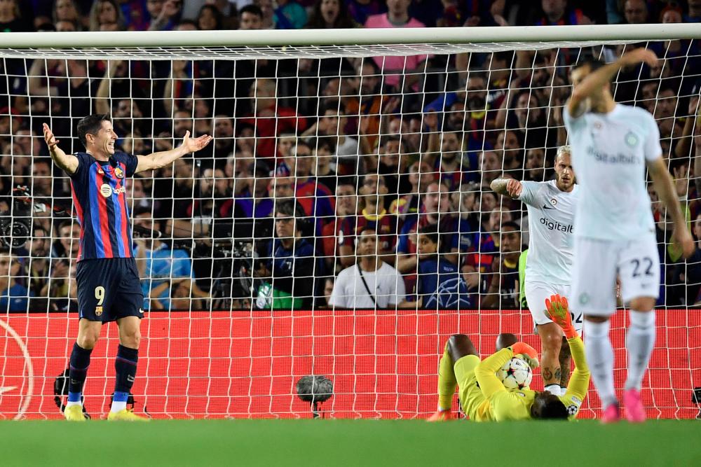 Barcelona's Polish forward Robert Lewandowski (L) reacts to Inter Milan's Cameroonian goalkeeper Andre Onana lying on the field during the UEFA Champions League 1st round, group C, football match between FC Barcelona and Inter Milan at the Camp Nou stadium/AFPPIX