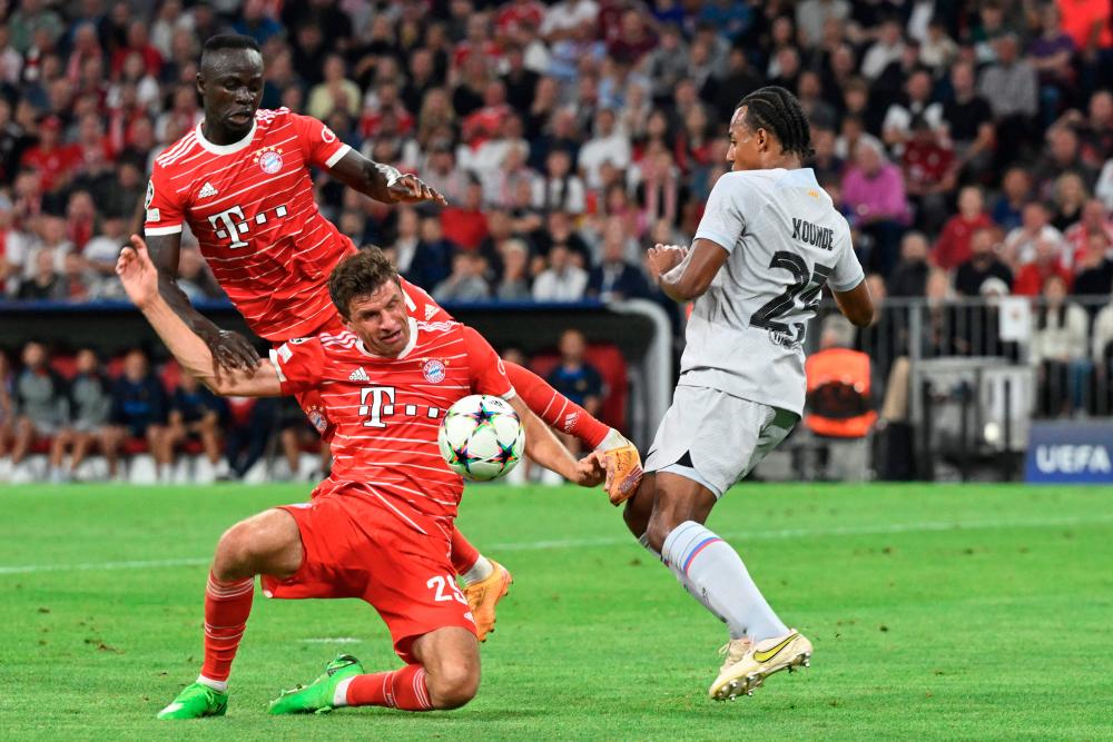Bayern Munich's German forward Thomas Mueller (C) and Bayern Munich's Senegalese forward Sadio Mane (L) collide next to Barcelona's French defender Jules Kounde (R) during the UEFA Champions League Group C football match between FC Bayern Munich and FC Barcelona in Munich/AFPPIX