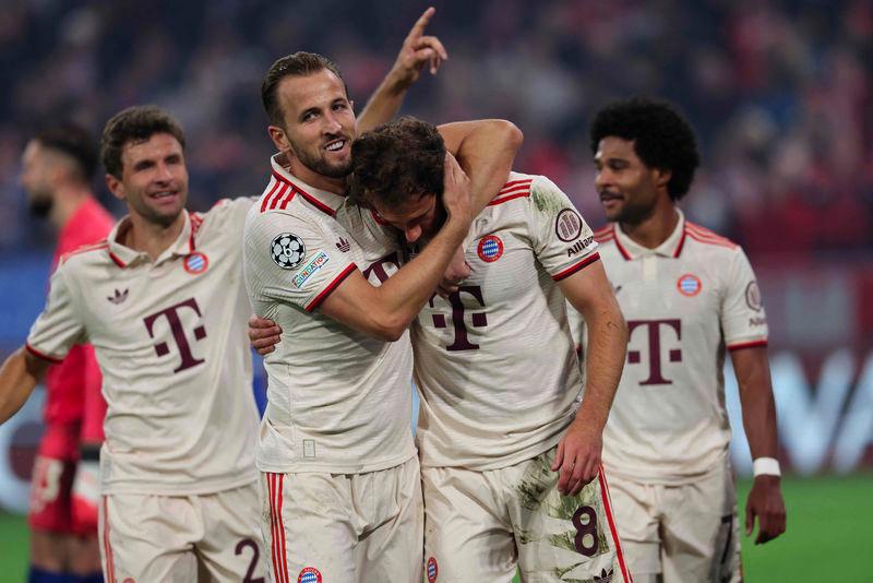 Bayern Munich's German midfielder #08 Leon Goretzka celebrates scoring the 9-2 goal with his teammates including Bayern Munich's English forward #09 Harry Kane during the UEFA Champions League football match FC Bayern Munich vs GNK Dinamo Zagreb in Munich, southern Germany, on September 17, 2024. - AFPPIX