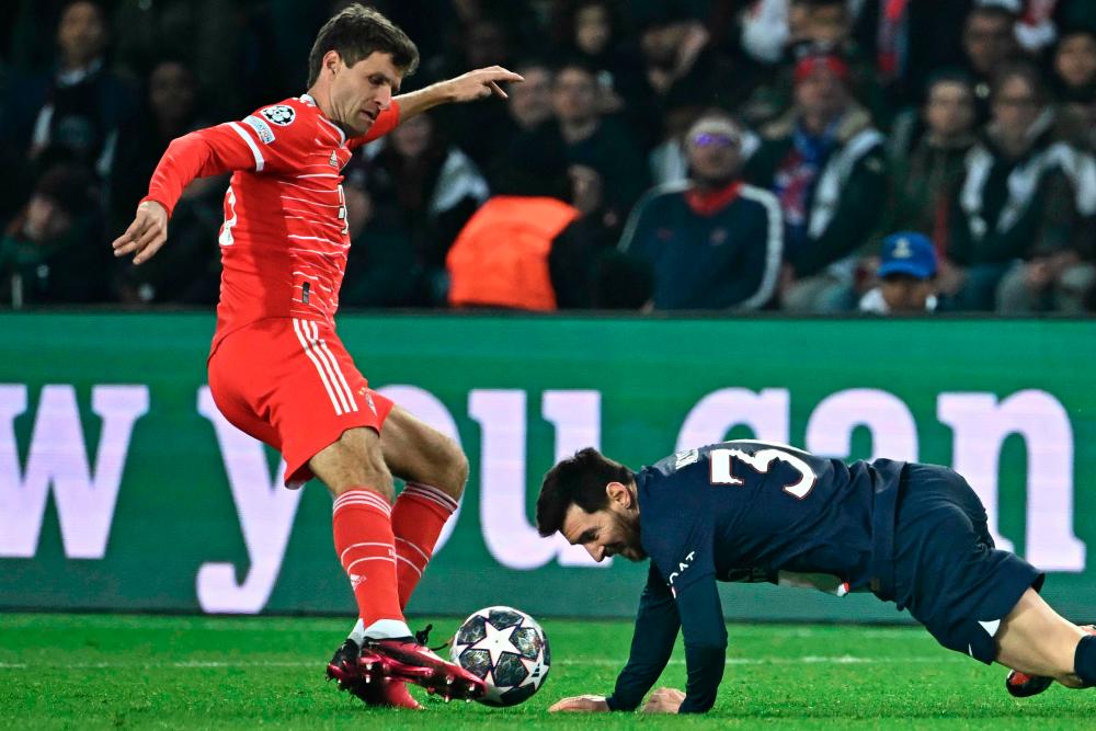 Bayern Munich's Thomas Mueller (L) fights for the ball with Paris Saint-Germain's Lionel Messi during the UEFA Champions League football match between Paris Saint-Germain (PSG) and Bayern Munich (FC Bayern Muenchen) at the Parc des Princes in Paris, on February 14, 2023. AFPPIX