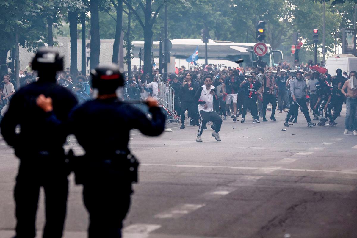 Police officers clash with crowd following the PSG team bus parade, near the Champs-Elysees avenue in Paris on June 1, 2025, a day after PSG won the 2025 UEFA Champions League final football match against Inter Milan in Munich. (Photo by Romain PERROCHEAU / AFP)