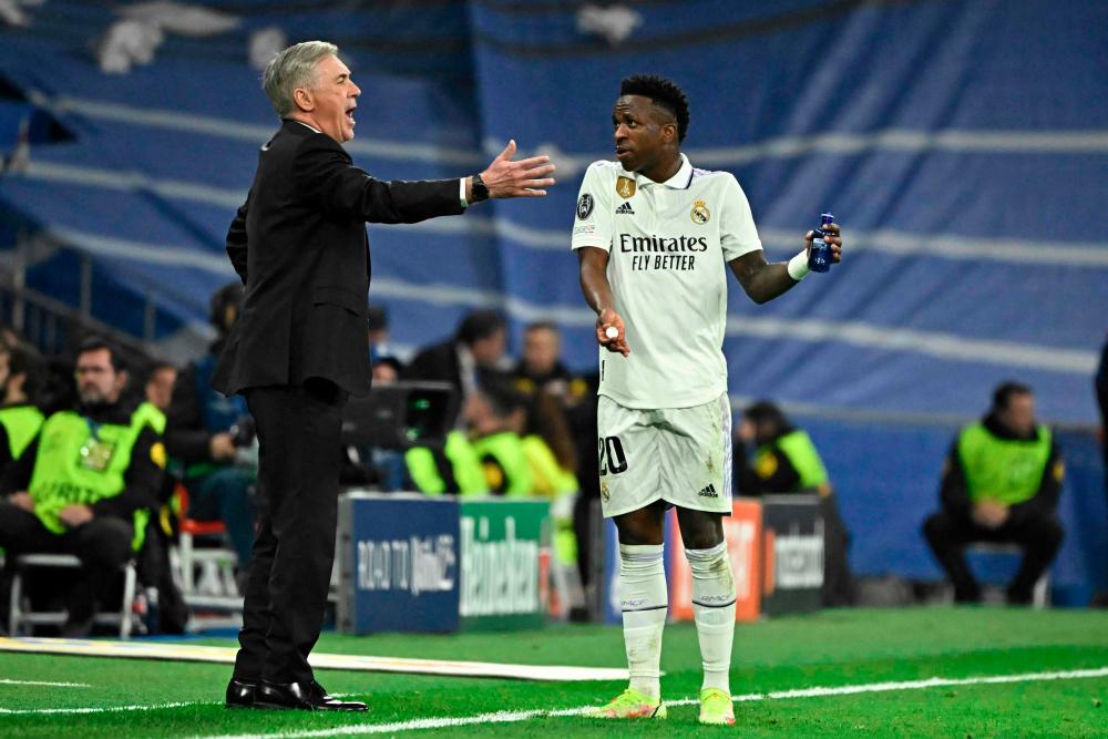 Real Madrid's Italian coach Carlo Ancelotti (L) talks with Real Madrid's Brazilian forward Vinicius Junior during the UEFA Champions League last 16 second leg football match between Real Madrid CF and Liverpool FC at the Santiago Bernabeu stadium in Madrid on March 15, 2023. AFPPIX