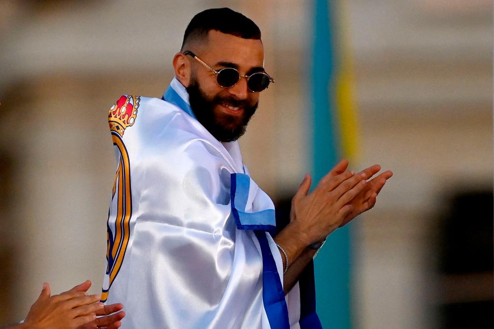 Real Madrid’s French forward Karim Benzema claps as he celebrates with teammates from an open-top bus during a parade through the streets of Madrid on May 29, 2022. AFPPIX