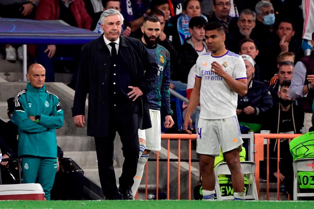 Real Madrid's Italian coach Carlo Ancelotti (L) and Real Madrid's Brazilian midfielder Casemiro react during the UEFA Champions League semi-final second leg football match between Real Madrid CF and Manchester City at the Santiago Bernabeu stadium in Madrid. AFPPIX