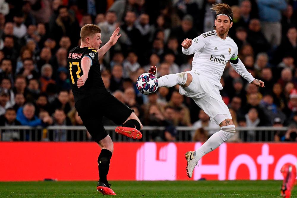 Real Madrid's Spanish defender Sergio Ramos (R) challenges Manchester City's Belgian midfielder Kevin De Bruyne during the Uefa Champions League round of 16 first-leg football match between Real Madrid CF and Manchester City at the Santiago Bernabeu stadium in Madrid on Feb 26, 2020. — AFP