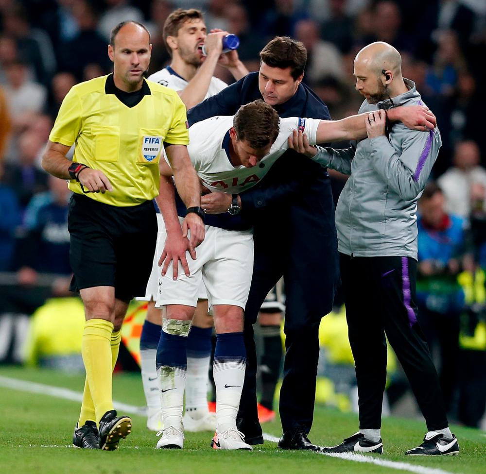 Tottenham Hotspur's Argentinian head coach Mauricio Pochettino (R2) helps Tottenham Hotspur's Belgian defender Jan Vertonghen (C) as he leaves the pitch injured during the UEFA Champions League semi-final first leg football match between Tottenham Hotspur and Ajax at the Tottenham Hotspur Stadium in north London, on April 30, 2019. — AFP