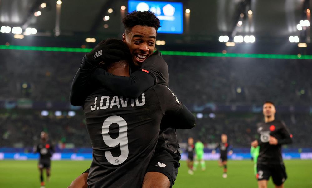 Lille's Canadian forward Jonathan David (front) celebrates scoring with his team-mate Lille's English midfielder Angel Gomes during the UEFA Champions League group G football match VfL Wolfsburg v Lille LOSC in Wolfsburg, northern Germany on December 8, 2021. AFPpix